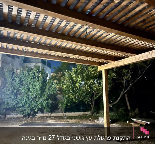 פרגולה מעץ בגינה עם עצים ברקע